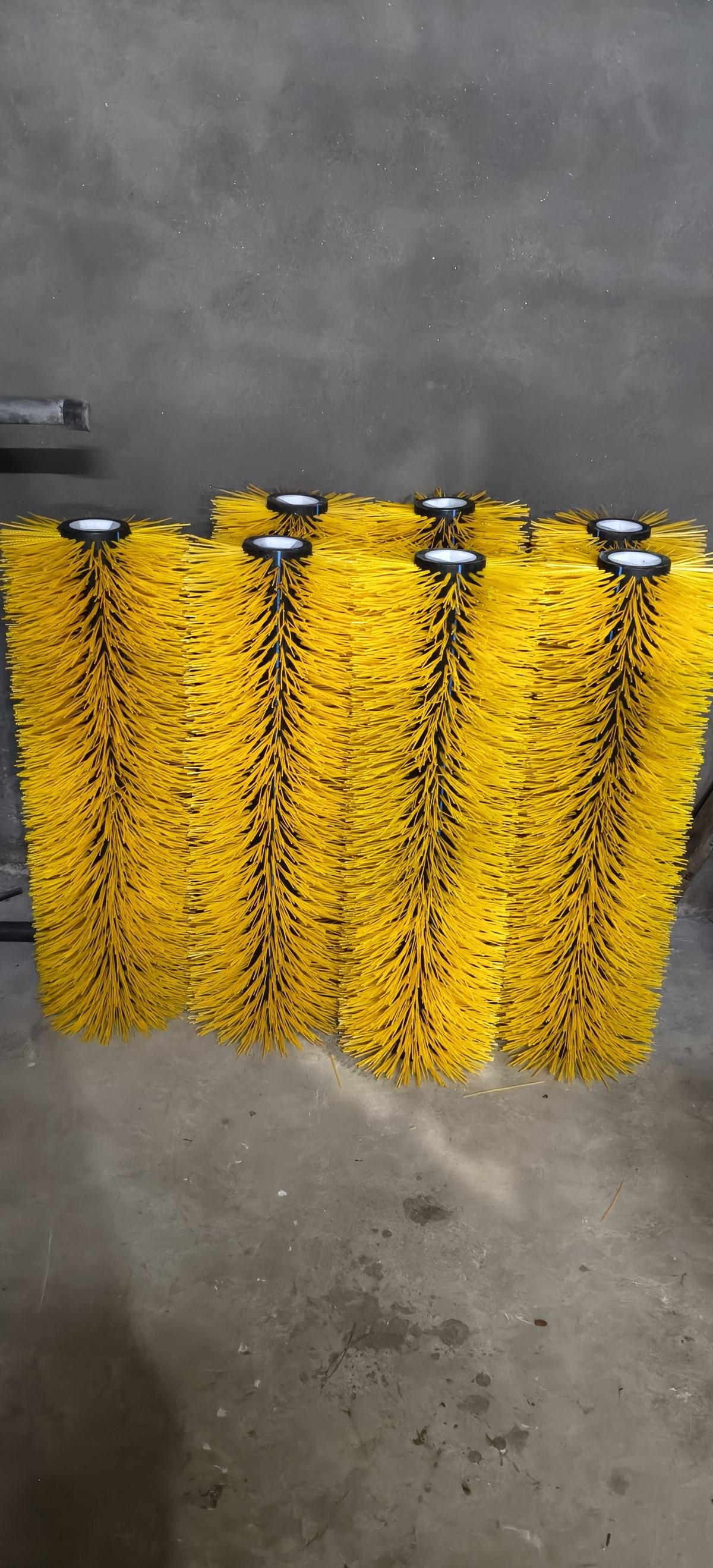 Row of yellow nylon road sweeper centre brushes with steel end caps